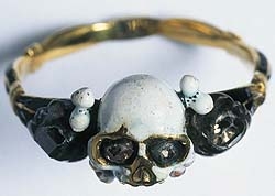 Gold and black enamel Mourning Ring from the Museum of London, features central skull in white on a gold band with black enamal to either side and in the skull orifices.